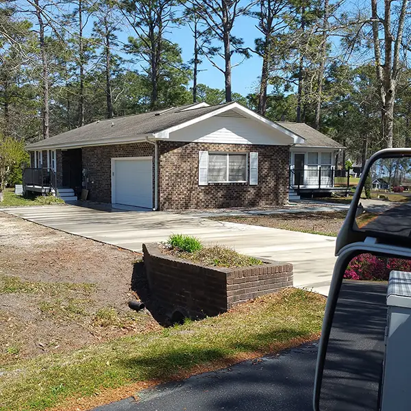 A Carolina Shores, NC house left sparkling clean by F Bomb Power Washing, house, driveway and flatwork power washed.